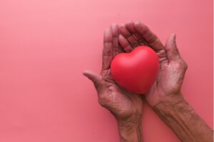 This picture is of a pair of hands holding a heart symbol. It is the header image for the 'make a regular donation' page on the Urostomy Association website.