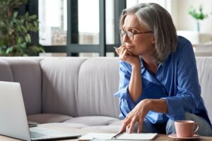 This is a photo of a woman looking at a laptop. It is the header image for the Urostomy Association's page on webinars.