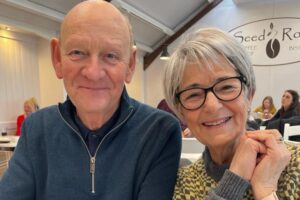 This is a photo of Wil Andrews and his wife, Sue. They are sitting in a cafe. It is the header image for his blog entitled 'Tailored solutions' on the Urostomy Association's website