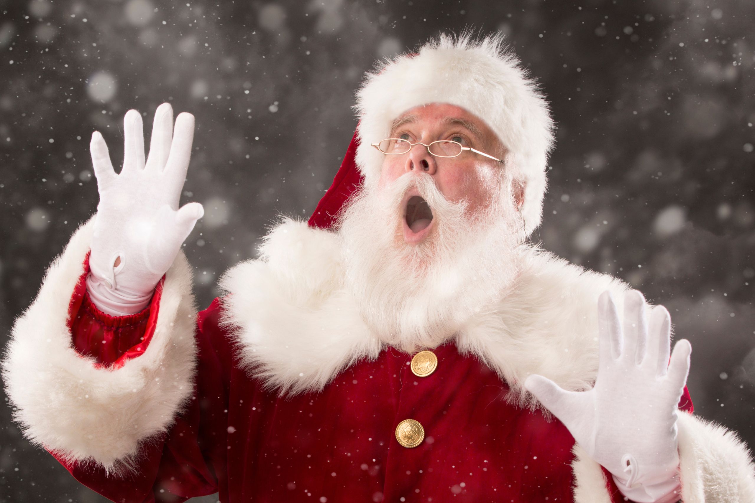 This is a photo of someone dressed as Father Christmas. He's singing. It is the header image for the Christmas Card page on the Urostomy Association's website