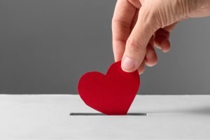 this is a photo of a red heart shape being posted into a white box