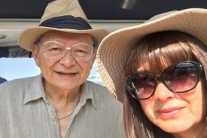 This photo is of Ian See and his daughter. They are both wearing sun hats and smiling directly into the camera.