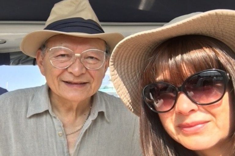 This photo is of Ian See and his daughter. They are both wearing sun hats and smiling directly into the camera.