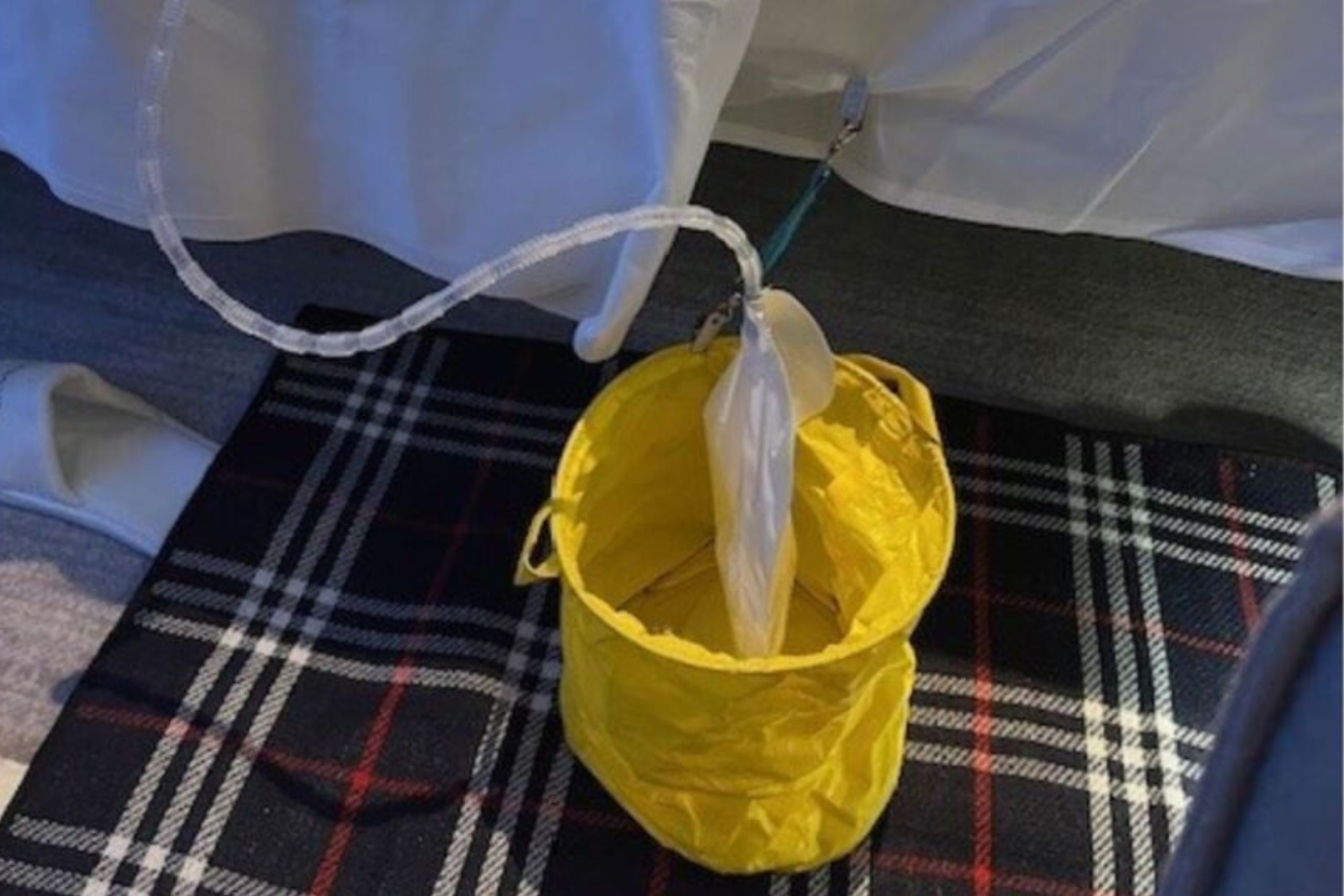 This photo is from supporter, John. It shows a collapsible yellow bowl into which he has placed his night bag. It is sitting on a tartan mat which has a waterproof liner