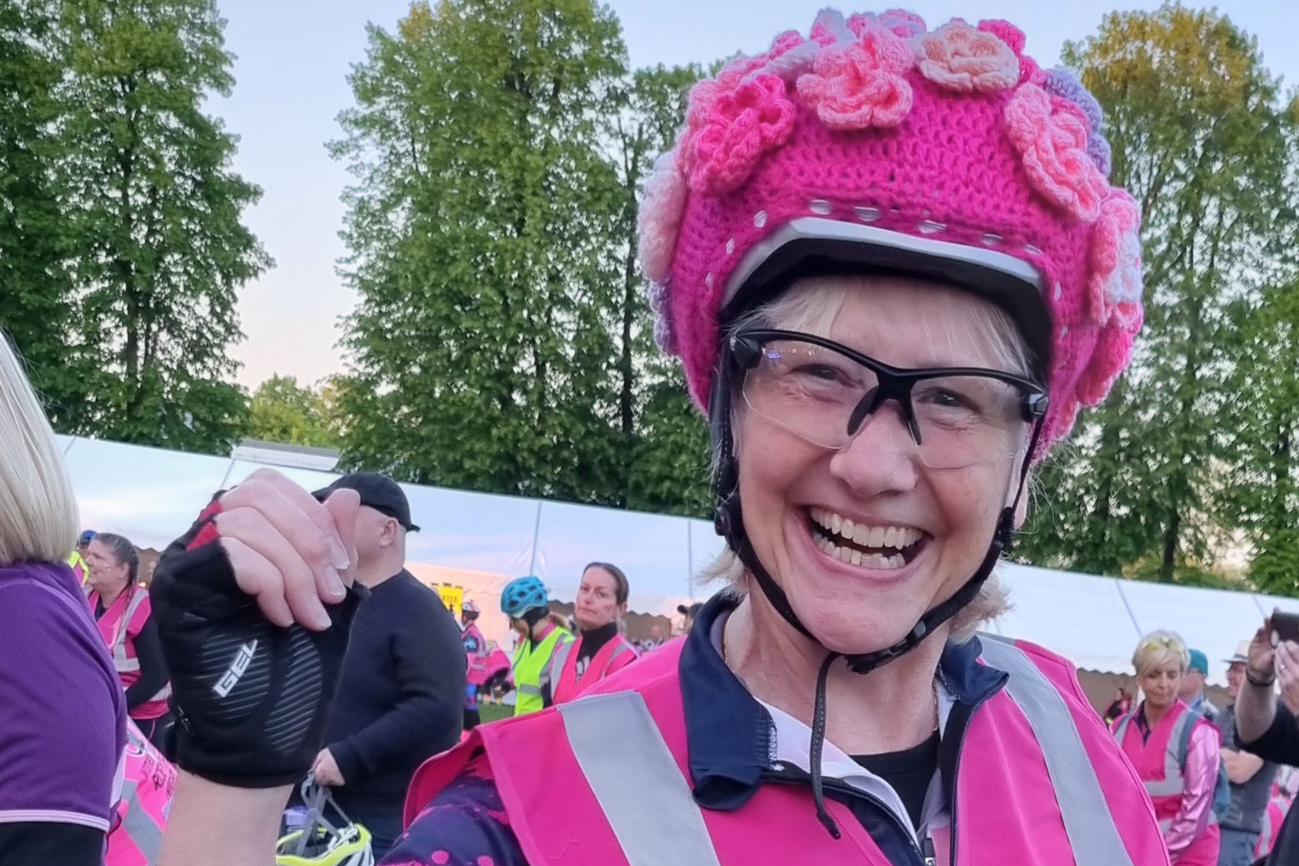 This photo is of the blog's author, Maureen. She is wearing a pink outfit for cycling, and has a crocheted cover on her helmet.