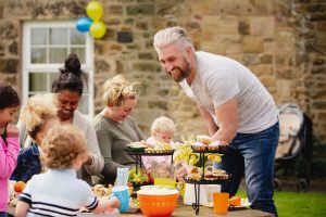 This photo shows an intergenerational garden tea party